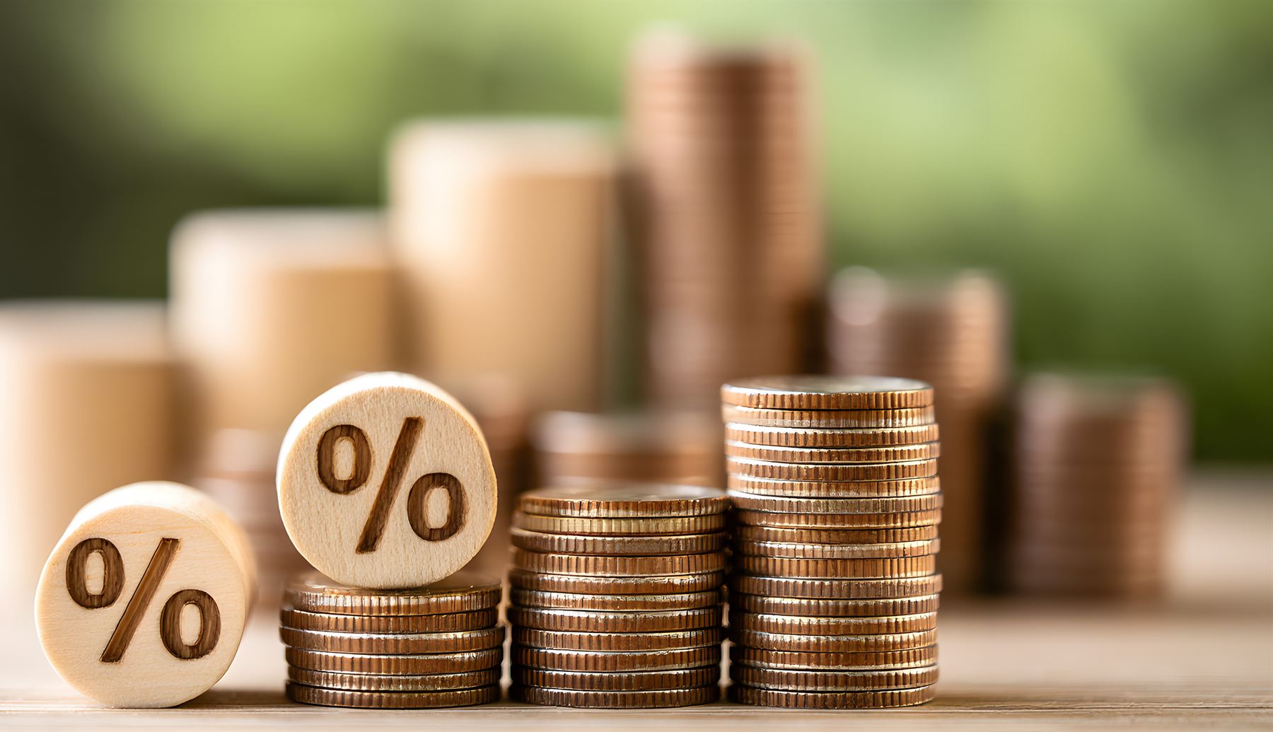 Stacks of coins with wooden percent-sign blocks