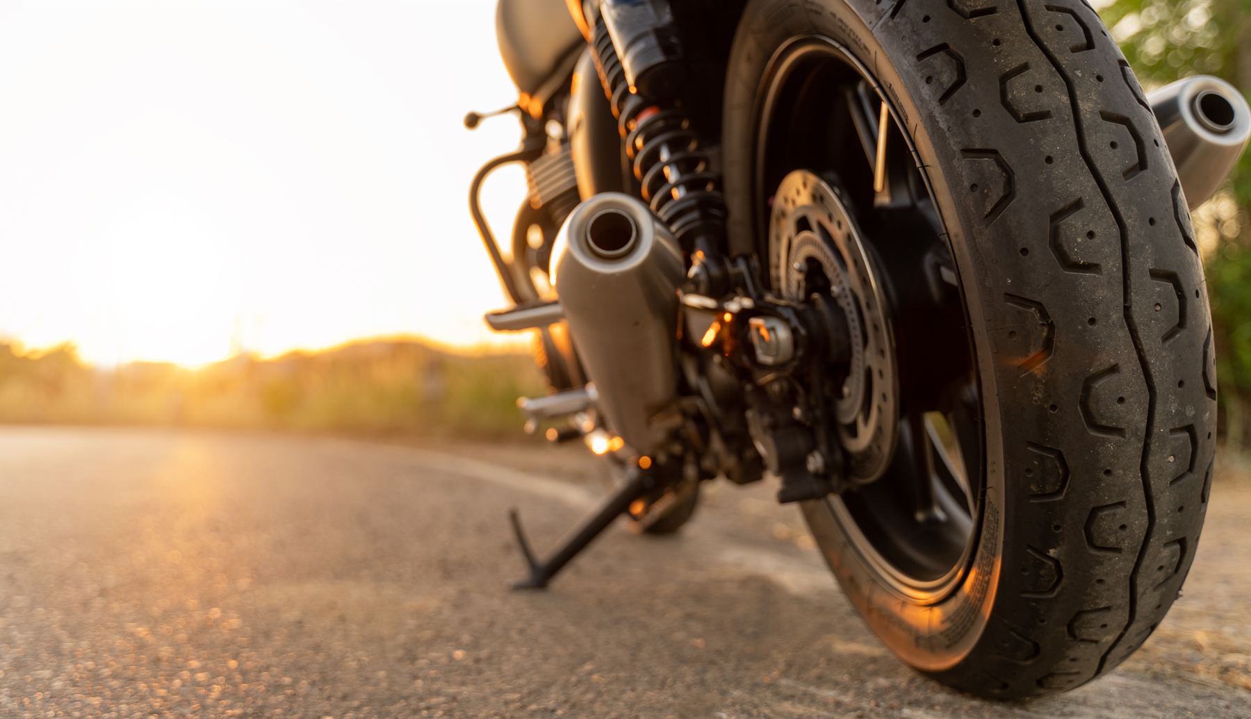 Motorcycle parked on a quiet road at sunset